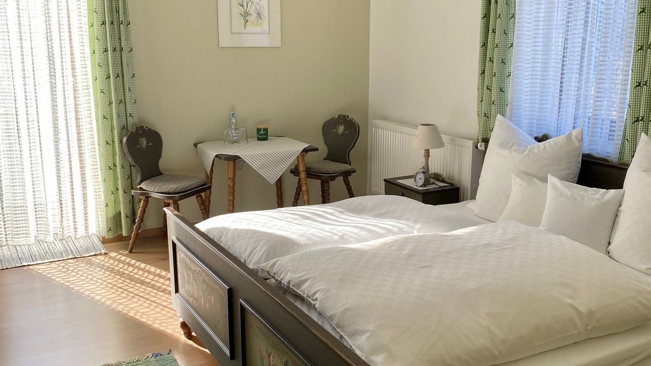 Ferienwohnung Wendelstein Schlafzimmer mit Doppelbett und Sitzgelegenheit Ferienwohnung Wendelstein Schlafzimmer mit Doppelbett und Sitzgelegenheit